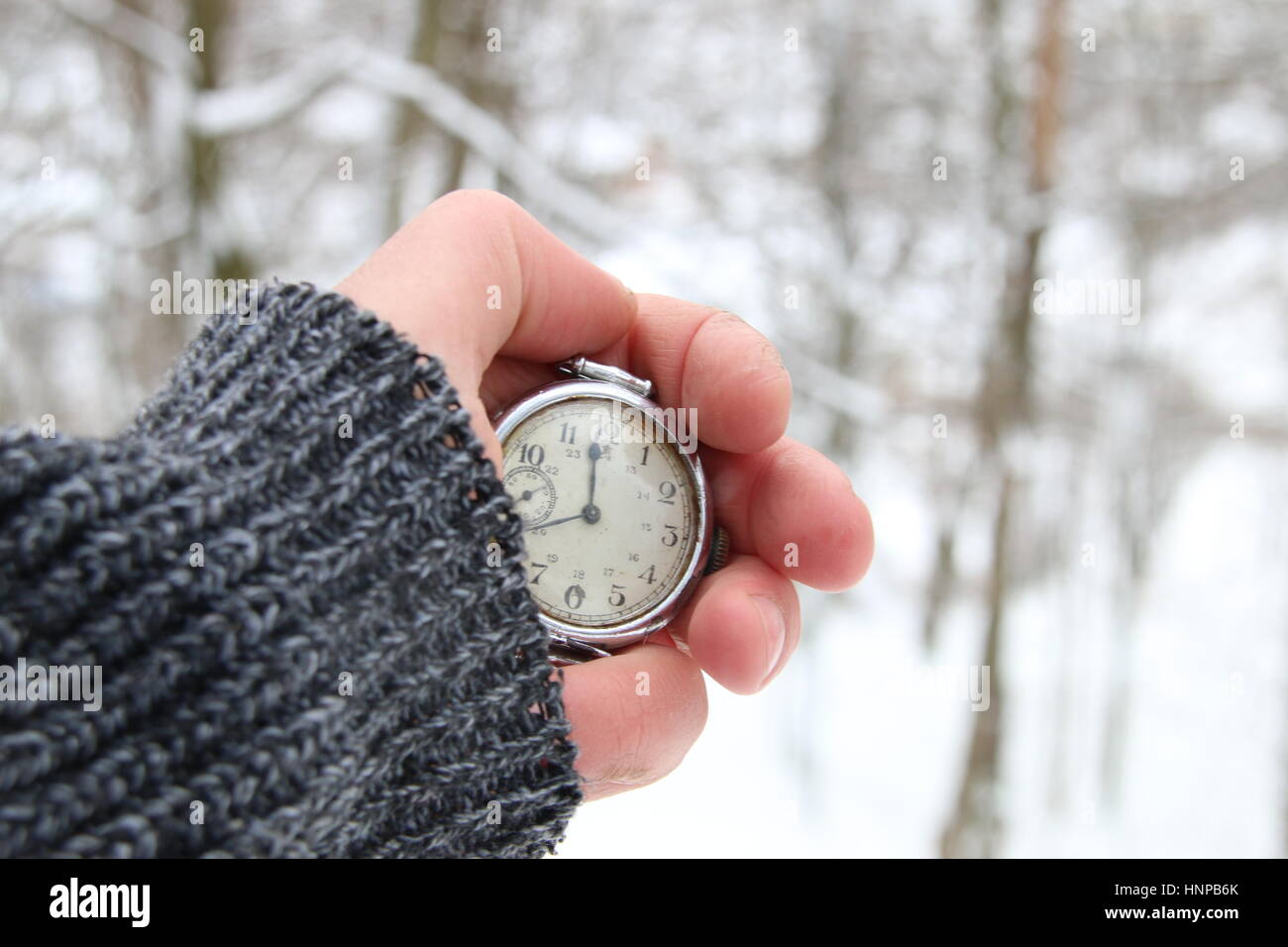 Winter-Zeit-Idee. Hand mit einer Taschenuhr. Stockfoto