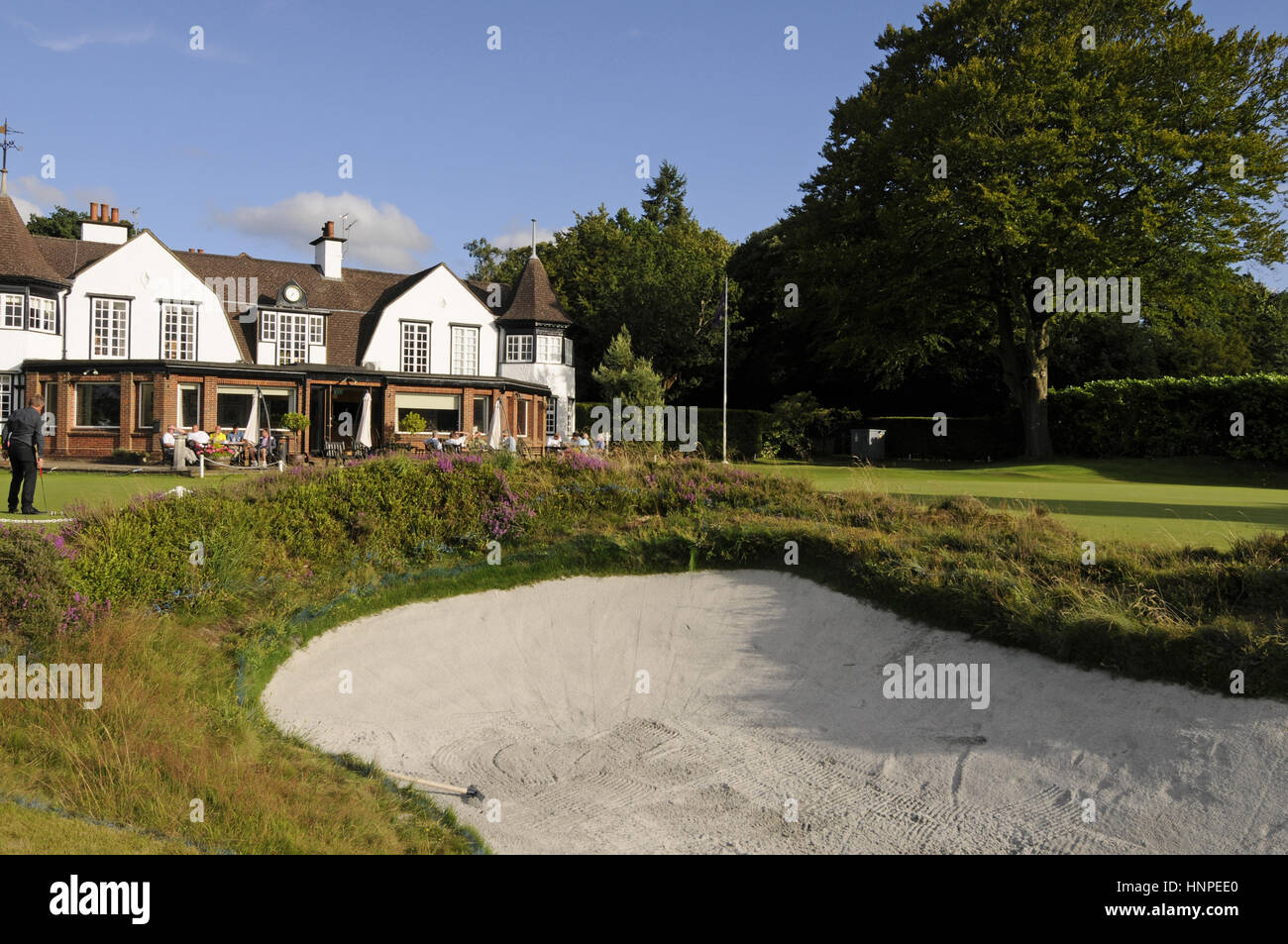 Blick über Greenside bunker mit Heather für das 18. Grün und das Clubhaus, Hindhead, Surrey, England Stockfoto