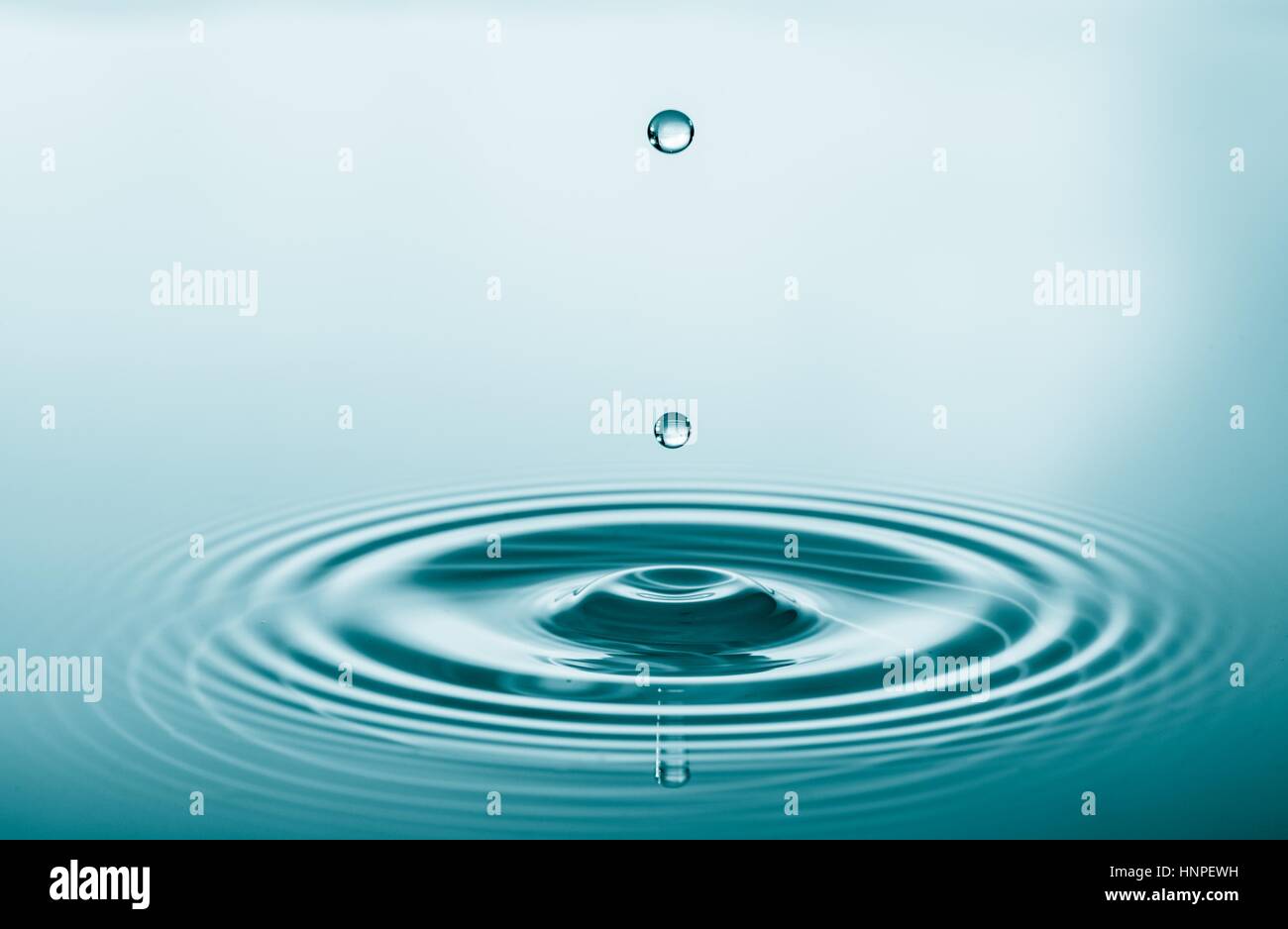 Wassertropfen fallen und tropft auf Wasser-Spiegel. Wasser Tropfen Splash und machen perfekte Kreise auf Wasseroberfläche Stockfoto