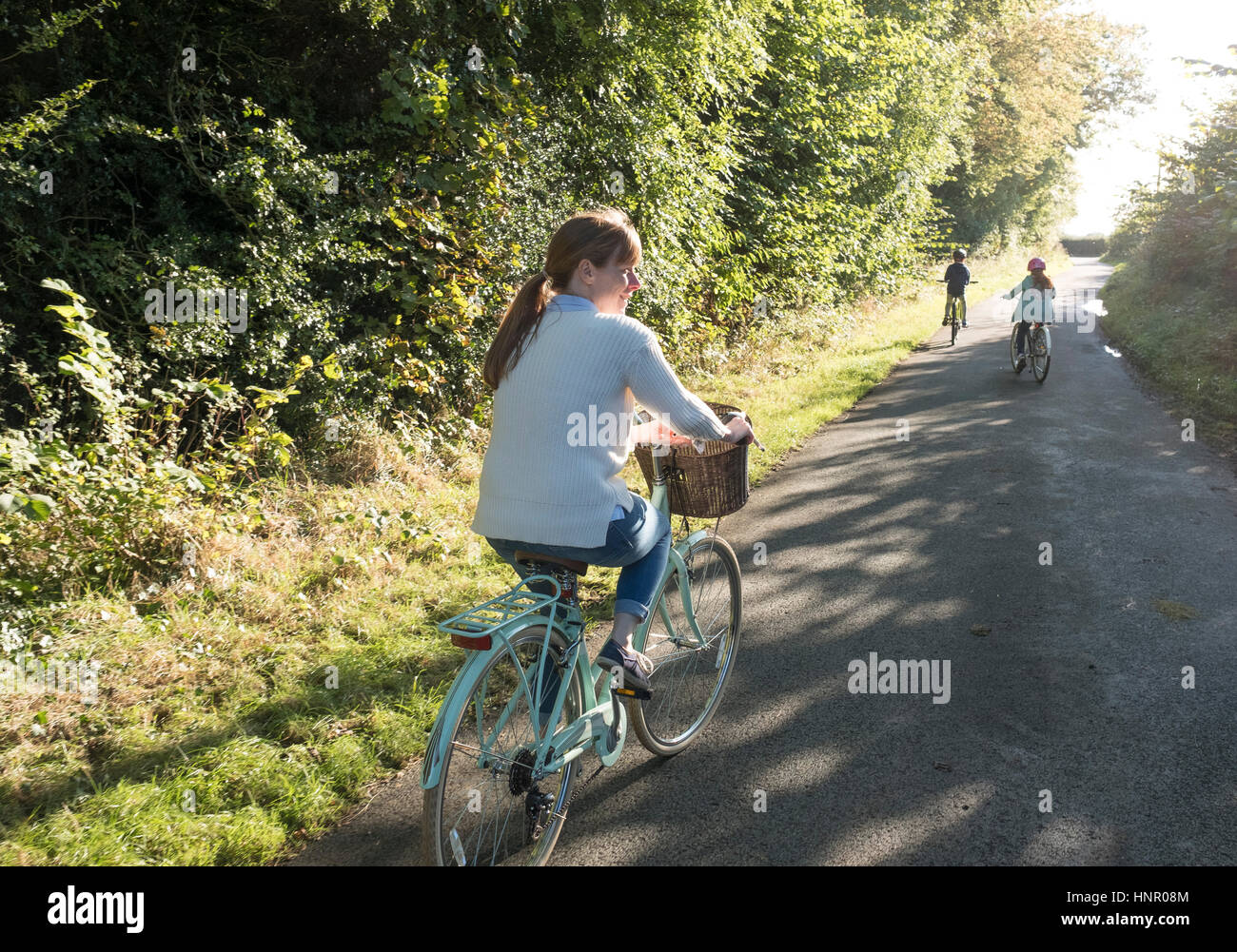 Eine Familie Radtour mit Mutter und zwei Kindern auf dem Lande. Stockfoto
