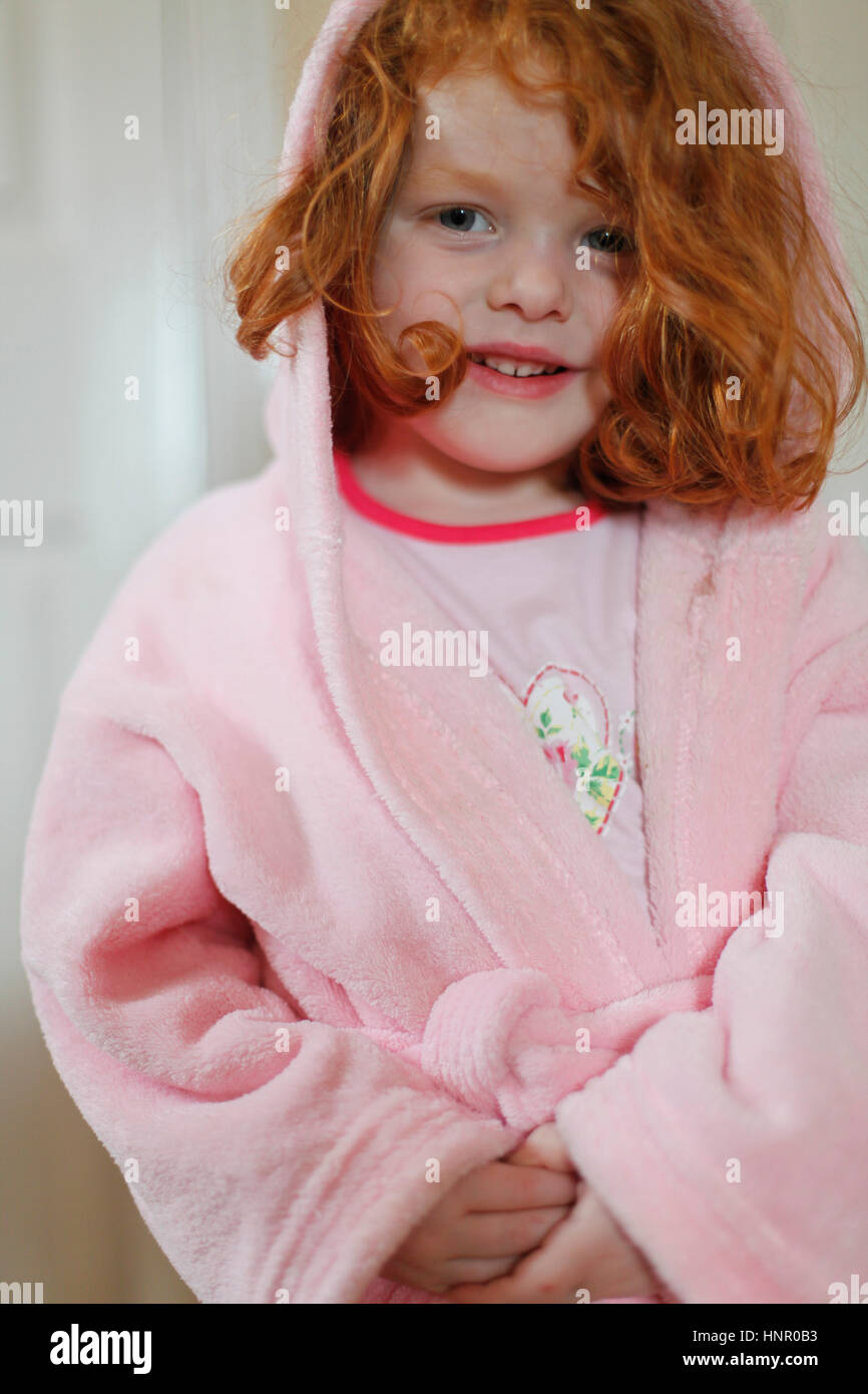 Ein 4 Jahre altes Mädchen mit Ingwer Haar in einen Morgenmantel Stockfoto