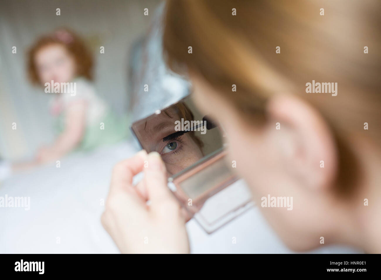 Eine Frau, die die Anwendung bilden, während ihre Tochter Uhren Stockfoto