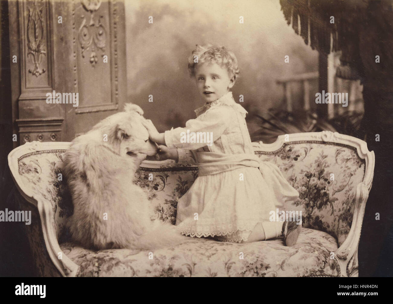 Archiv Bild: viktorianische Porträt eines jungen Kleid mit Haustier Hund auf Couch Stockfoto