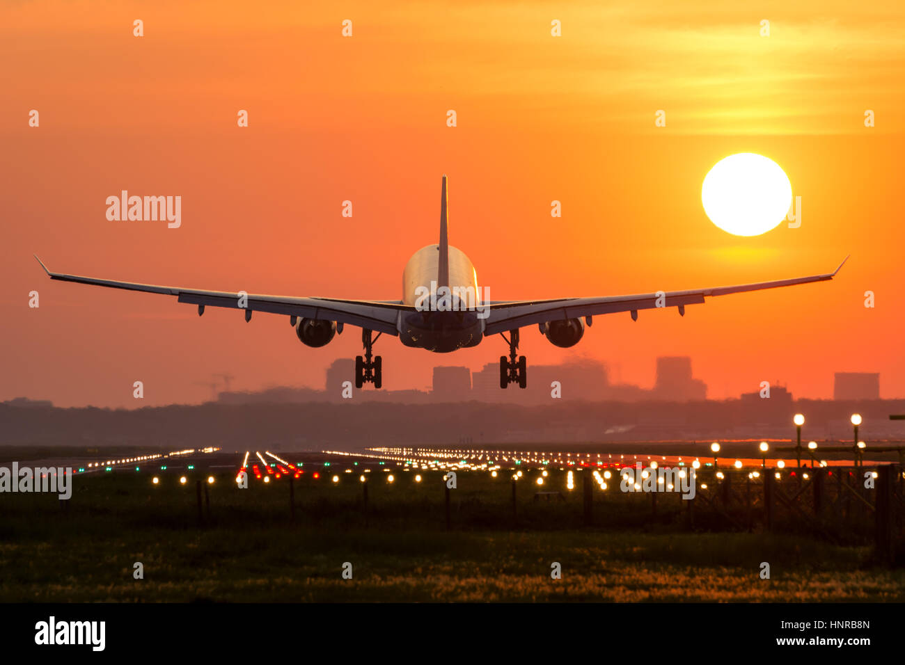 Passagierflugzeug ist in einem wunderschönen Sonnenaufgang landen. Das Flugzeug ist fast auf der Start-und Landebahn gelandet. Stockfoto