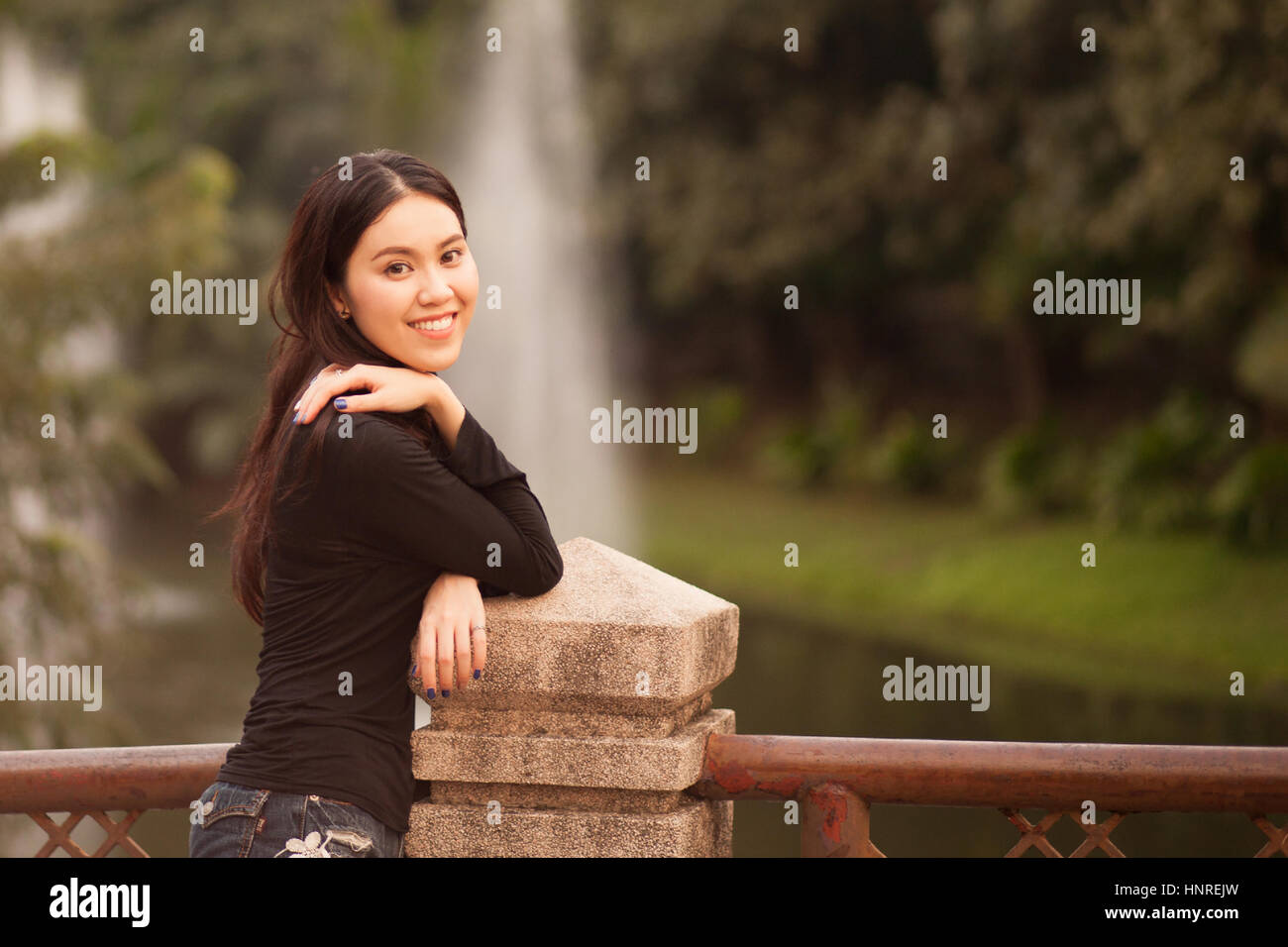 Ziemlich Thai Mädchen lächelnd im Park Stockfoto