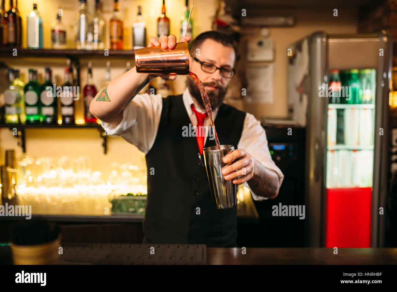 Barkeeper zeigen hinter Restaurant-Bar-Theke. Gut aussehend Alkohol Getränkezubereitung Stockfoto