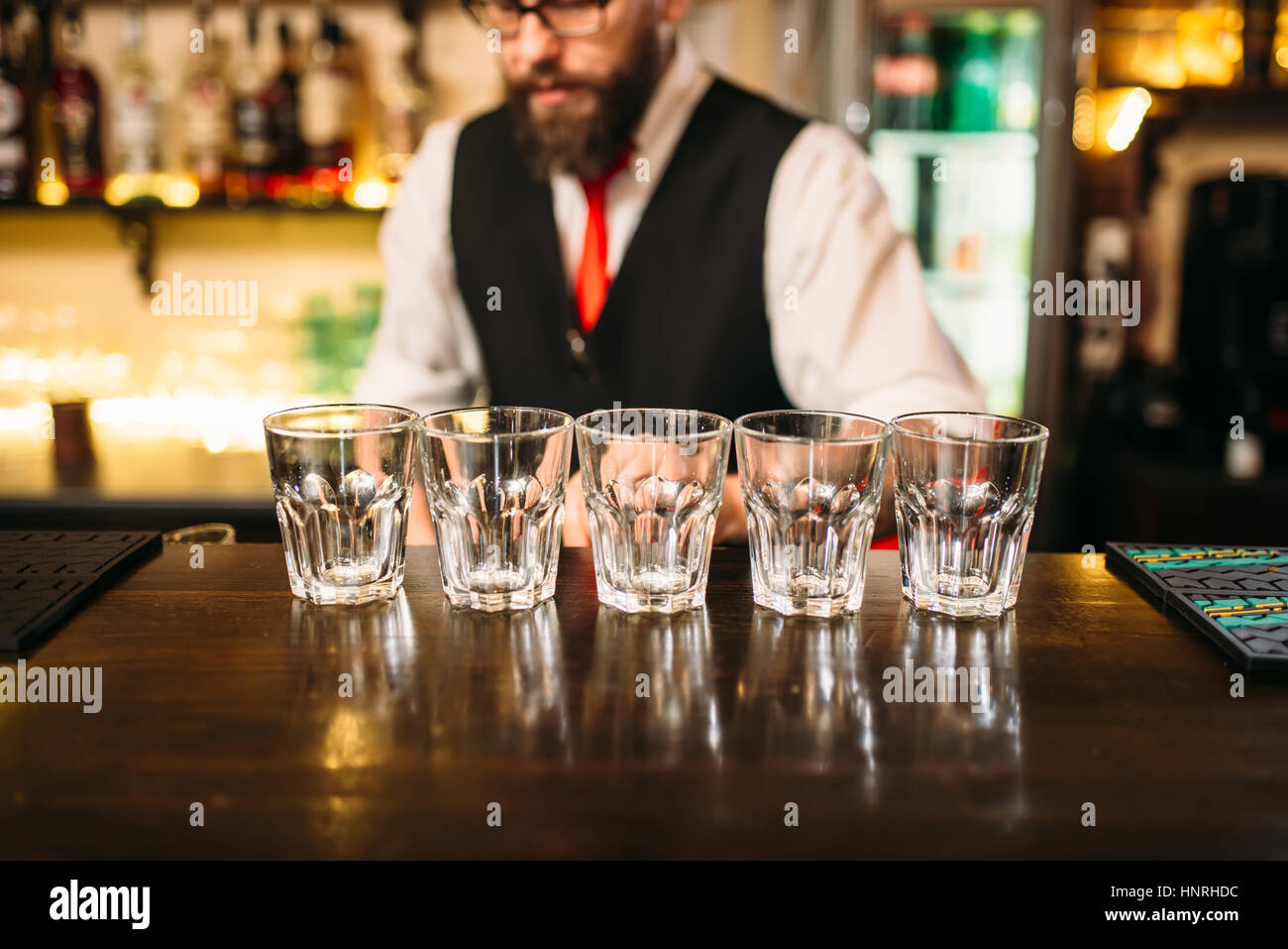 Leere Gläser auf Holzbar Theke, Barkeeper arbeiten auf Hintergrund Stockfoto