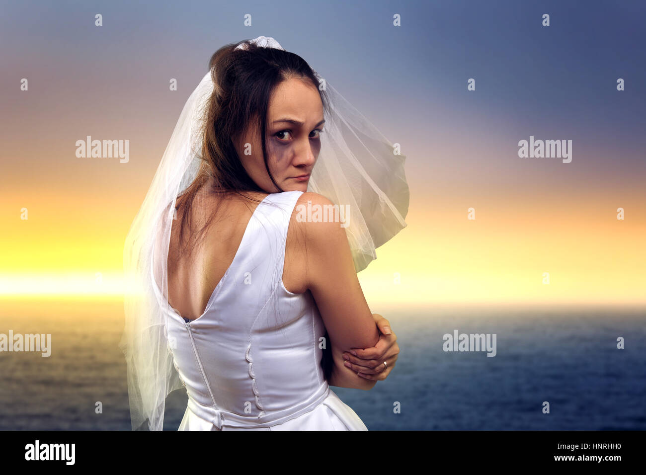 Tränenreiche Braut auf dem Hintergrund auf das Meer und Sonnenuntergang Stockfoto