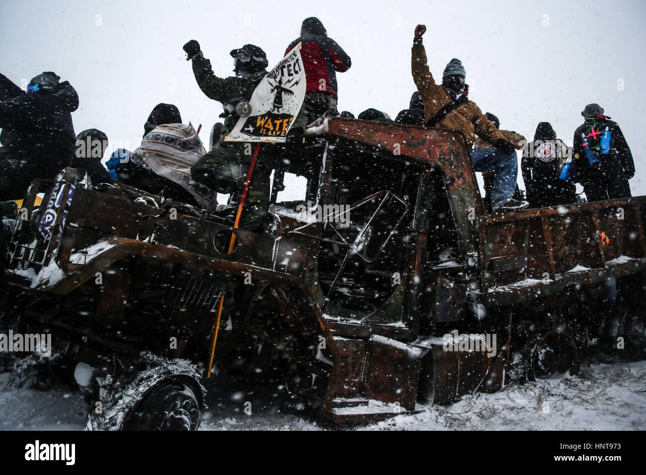 Kanonenkugel, North Dakota, USA. 5. Dezember 2016. Demonstranten stehen auf einem verlassenen und verbrannt Fahrzeug am Highway 1806 während einer Aktion gegen die Dakota-Zugang-Pipeline. Bildnachweis: Joel Angel Juarez/zReportage.com/ZUMA Draht/Alamy Live-Nachrichten Stockfoto