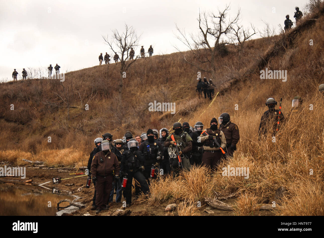 Kanonenkugel, North Dakota, USA. 24. November 2016. Behörden Gesicht Wasser Protektoren land wie sie sie von Verfahren blockieren weiter in Richtung der Baustelle der Dakota Zugang Pipeline auf Army Corps of Engineers in Kanonenkugel, North Dakota. Nach dem Morton County Sheriffs Department hat es Hilfe von 24 Grafschaften, 16 Städte und 9 anderen Staaten seit August 2016 erhalten. Unbewaffnete Demonstranten, wer auf dem Army Corps of Engineers Land an der Grenze der Standing Rock Indian Reservation camping wurde, wurden mit Pfefferspray, Gummigeschossen und Wasserwerfern in eisigen Tem getroffen Stockfoto