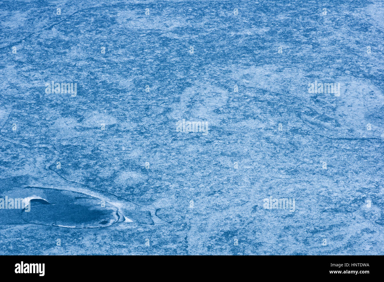 fast vollständig gefrorenen Gletschersee mit komplizierten Mustern und Risse im Eis und Wasser Stockfoto