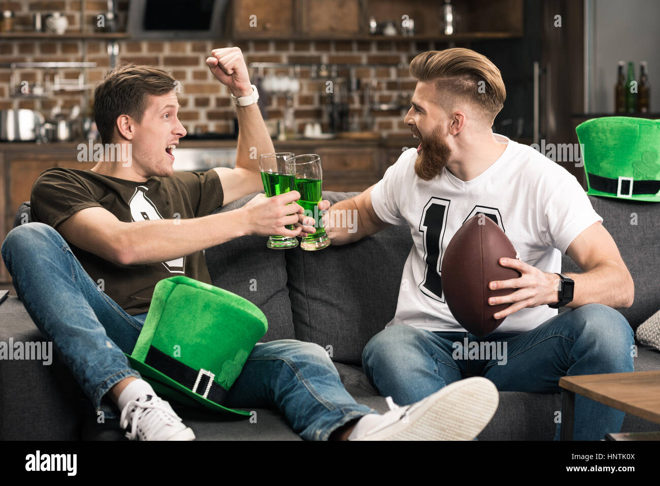 Männer Klirren Biergläser bei St Patricks Tag Stockfoto