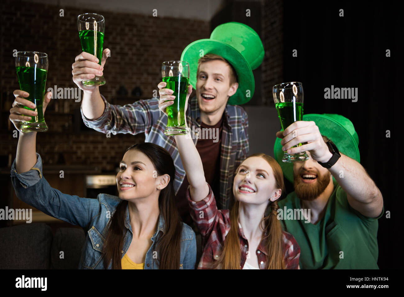 Freunde halten Gläser mit Bier am St. Patricks Day Feier Stockfoto