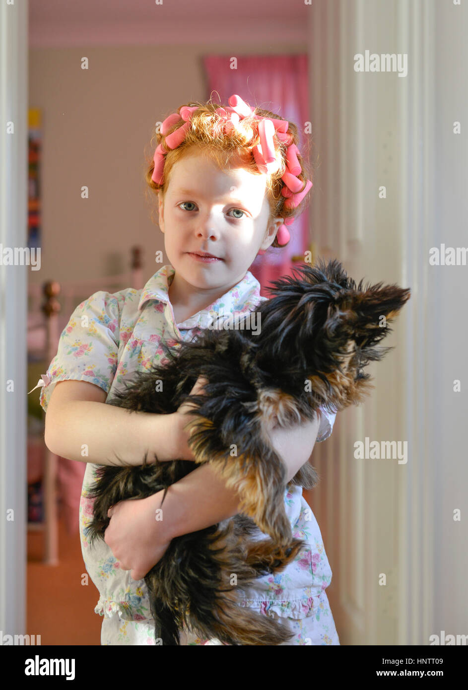 Ein kleines Mädchen in Rollen, die mit ihrem Hund Stockfoto