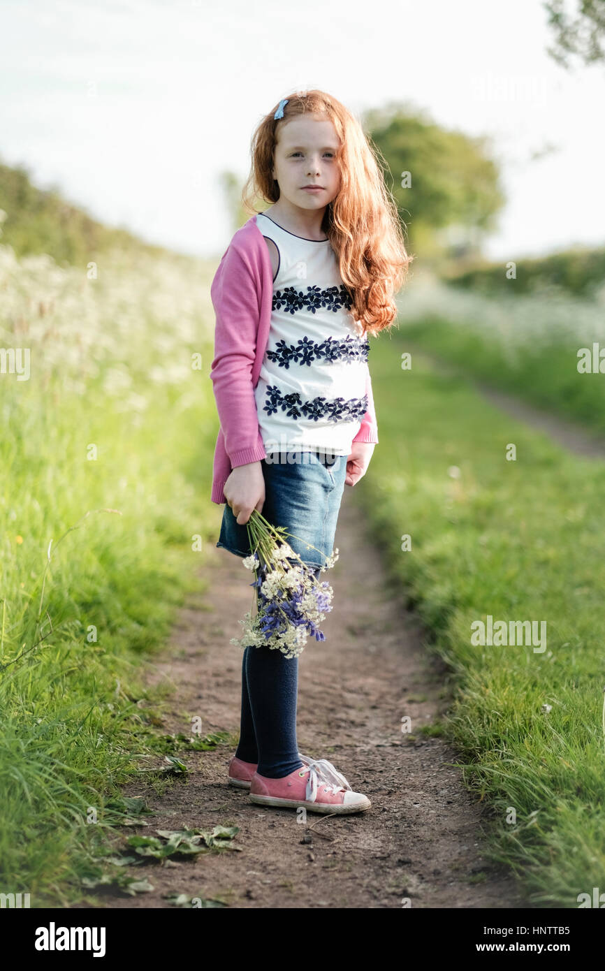 Ein kleines Mädchen im grünen Blumen zu pflücken. Stockfoto