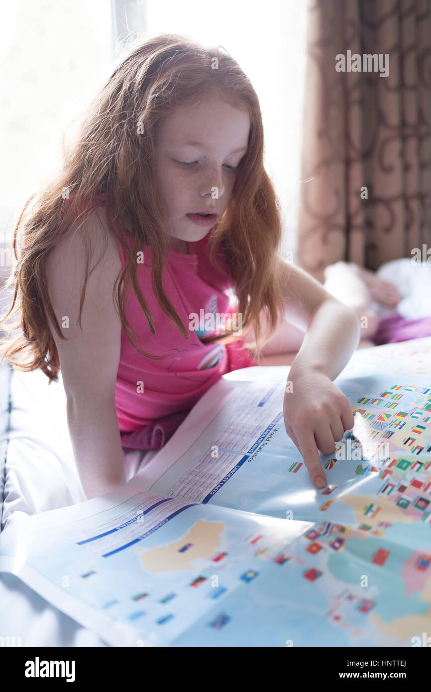 Ein kleines Mädchen Blick auf eine Karte in ihrem Schlafzimmer Stockfoto