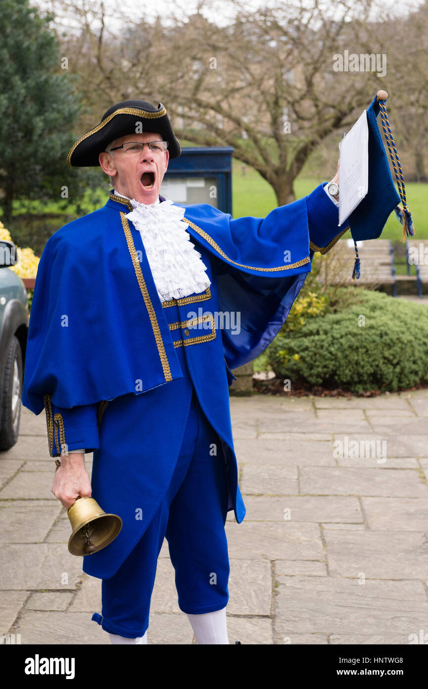 Ein männlicher Stadtschrei (blaues Kostüm, Tricorne-Hut, Spitzenjabot und Rüschen, Rolle in der Hand) macht laute öffentliche Ankündigung - Ilkley, West Yorkshire, England, Großbritannien. Stockfoto