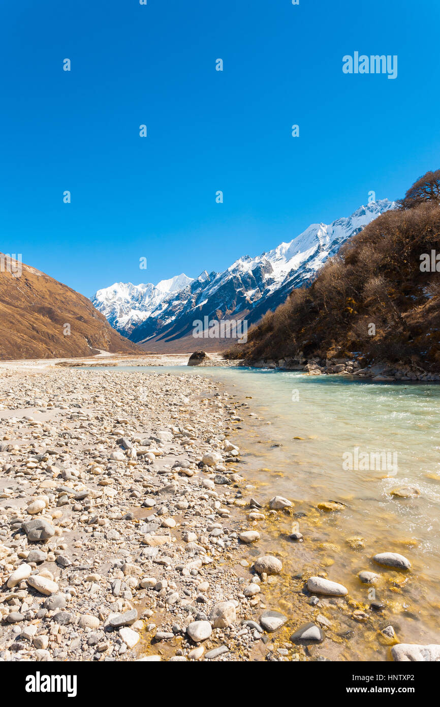 Langtang-Tal in großer Höhe mit fließenden Gletscherfluss Wasser vom Himalaya-Gebirge und schneebedeckten Gipfel der Gangchenpo im Hintergrund in Nepa Stockfoto