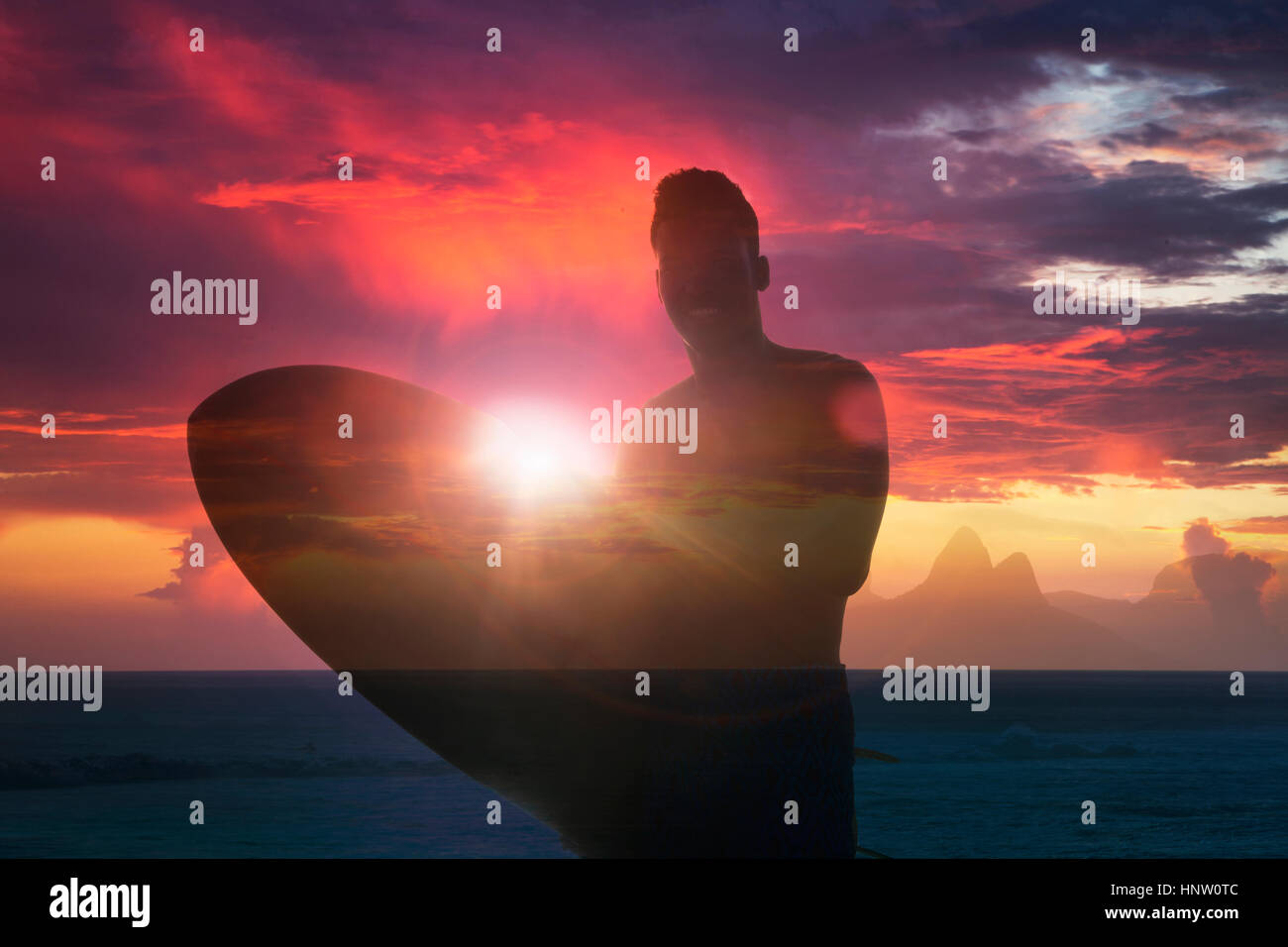 Doppelbelichtung lächelnder Mischlinge Mann Holding Surfbrett am Strand Stockfoto