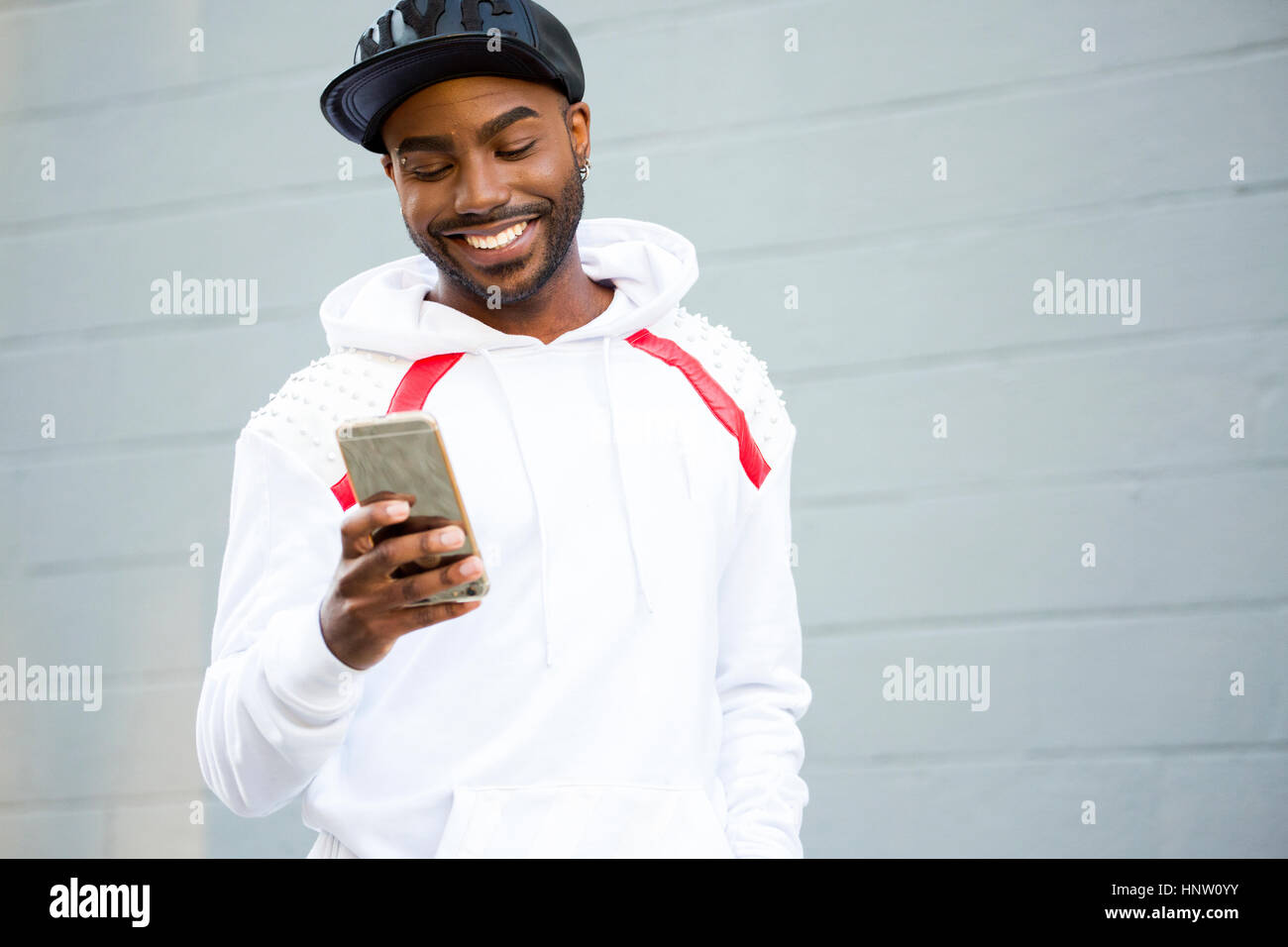 Lächelnde schwarzer Mann SMS auf Handy Stockfoto