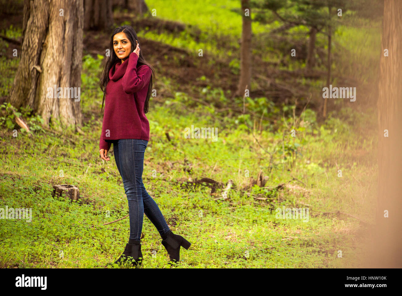 Lächelnde indische Frau posiert im Wald Stockfoto