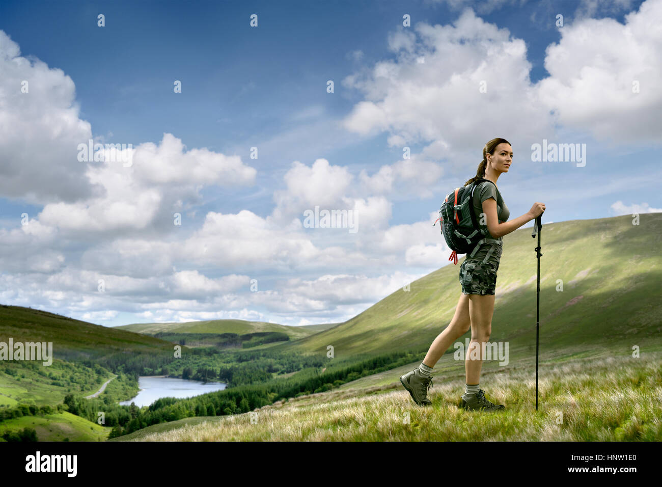 Kaukasische Frau Wandern auf grünen Hügel Stockfoto