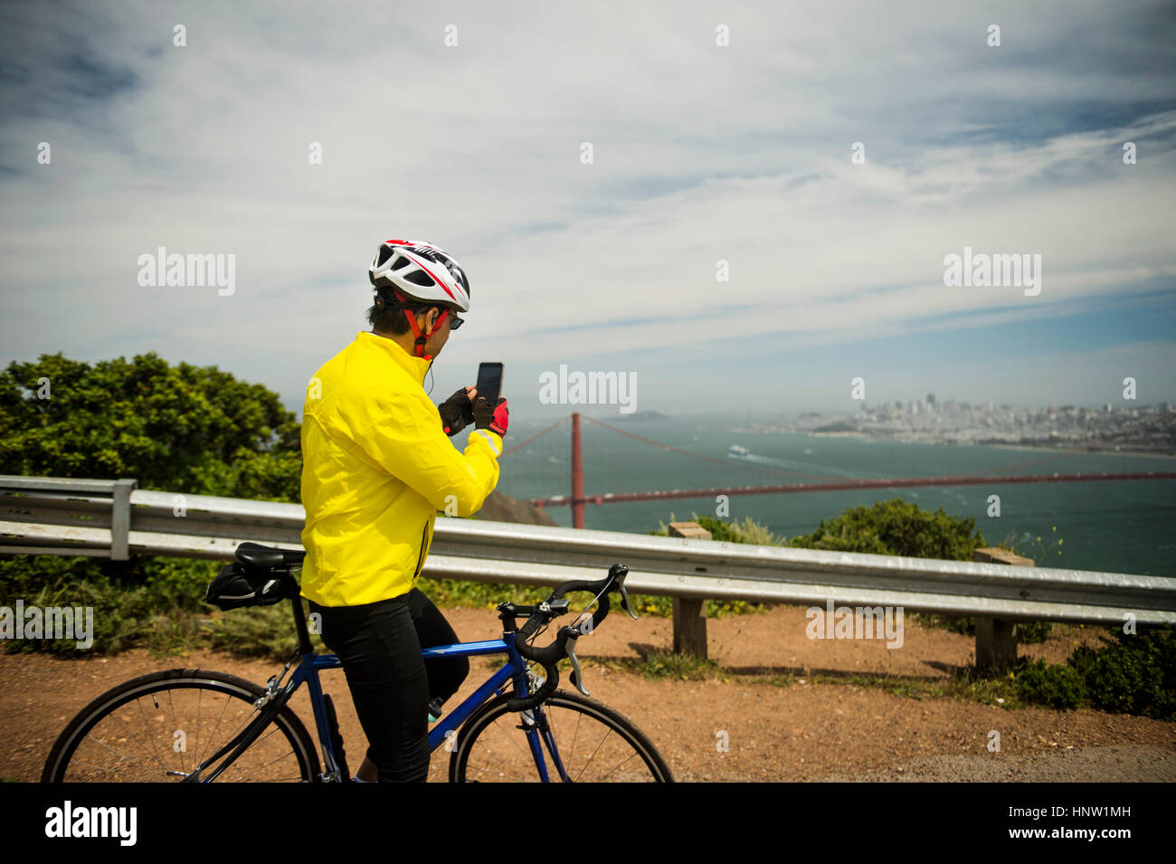 Hispanische Mann mit Fahrrad fotografieren Waterfront mit Handy Stockfoto