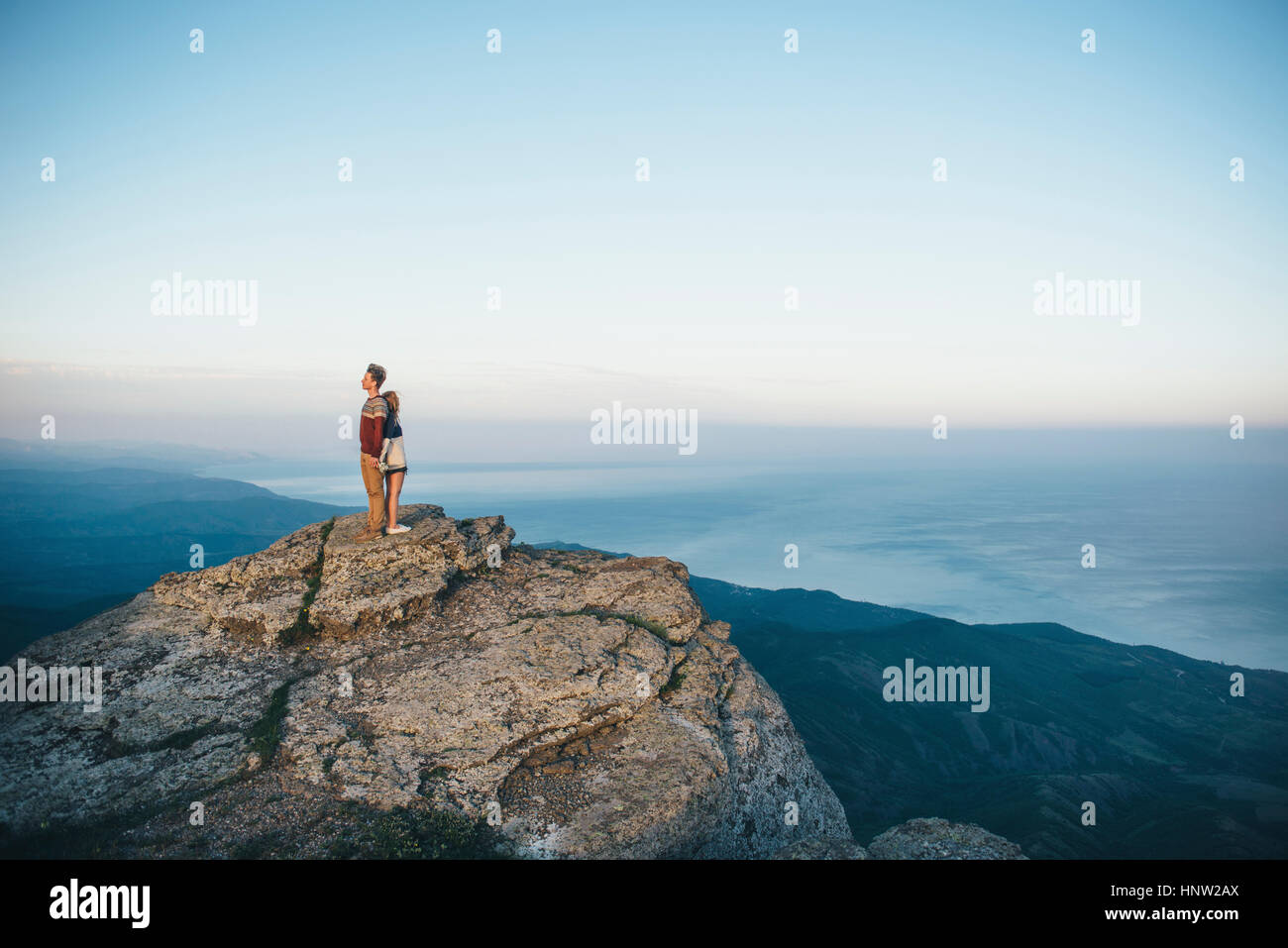 Kaukasische paar stehen Rücken an Rücken auf Berg Stockfoto