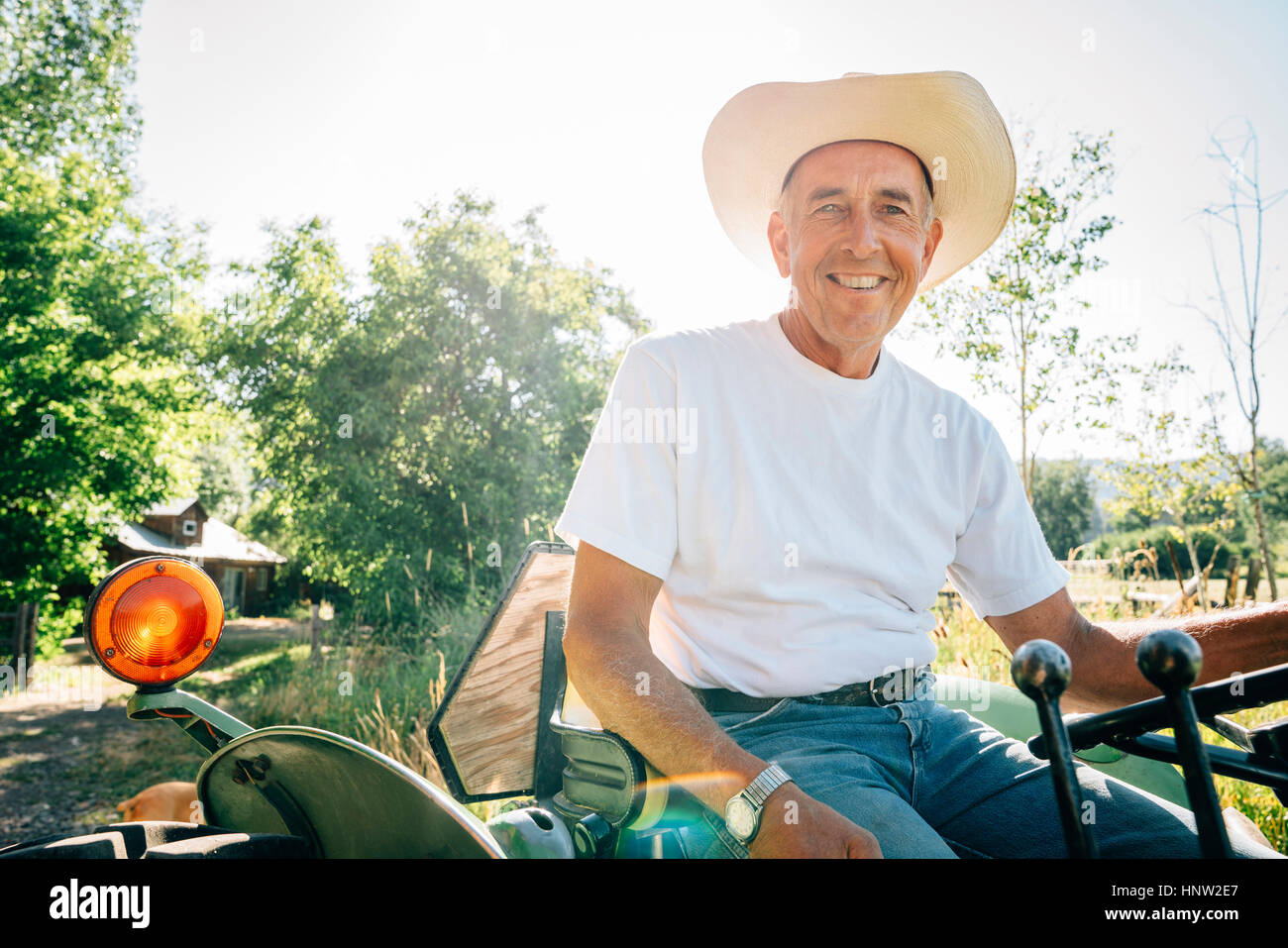 Kaukasische Bauer auf dem Traktor sitzen Stockfoto