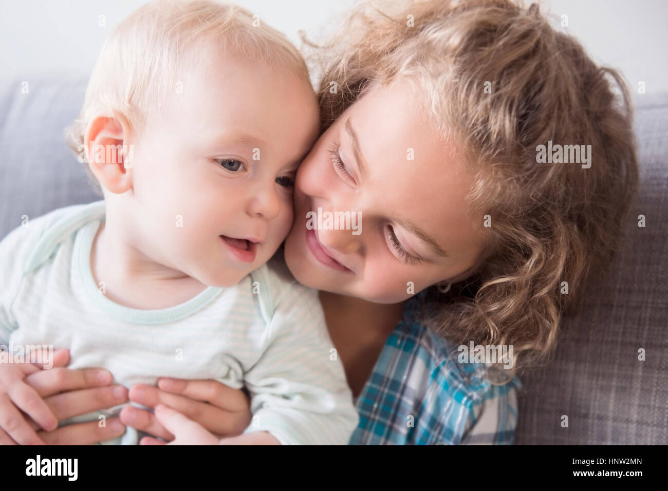 Lächelndes kaukasische Mädchen hält Baby Bruder Stockfoto