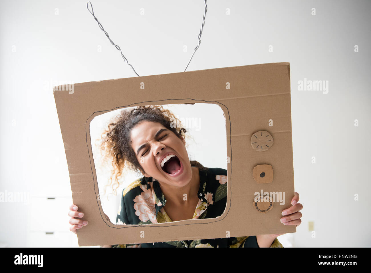 Gemischte Rennen Frau schreiend im Karton Fernsehen Stockfoto