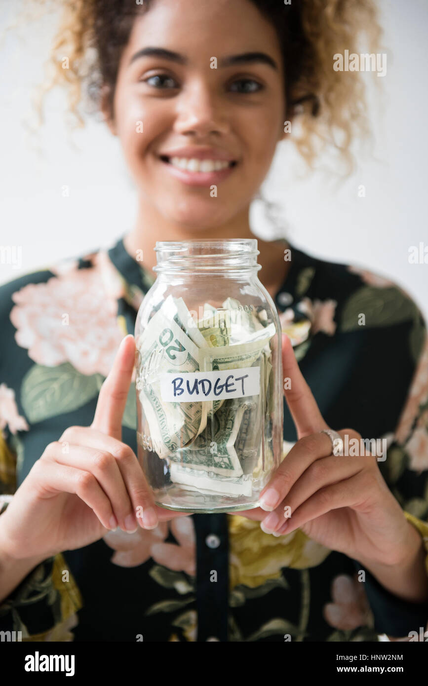 Gemischte Rennen Frau mit Glas Haushalt Geld Stockfoto