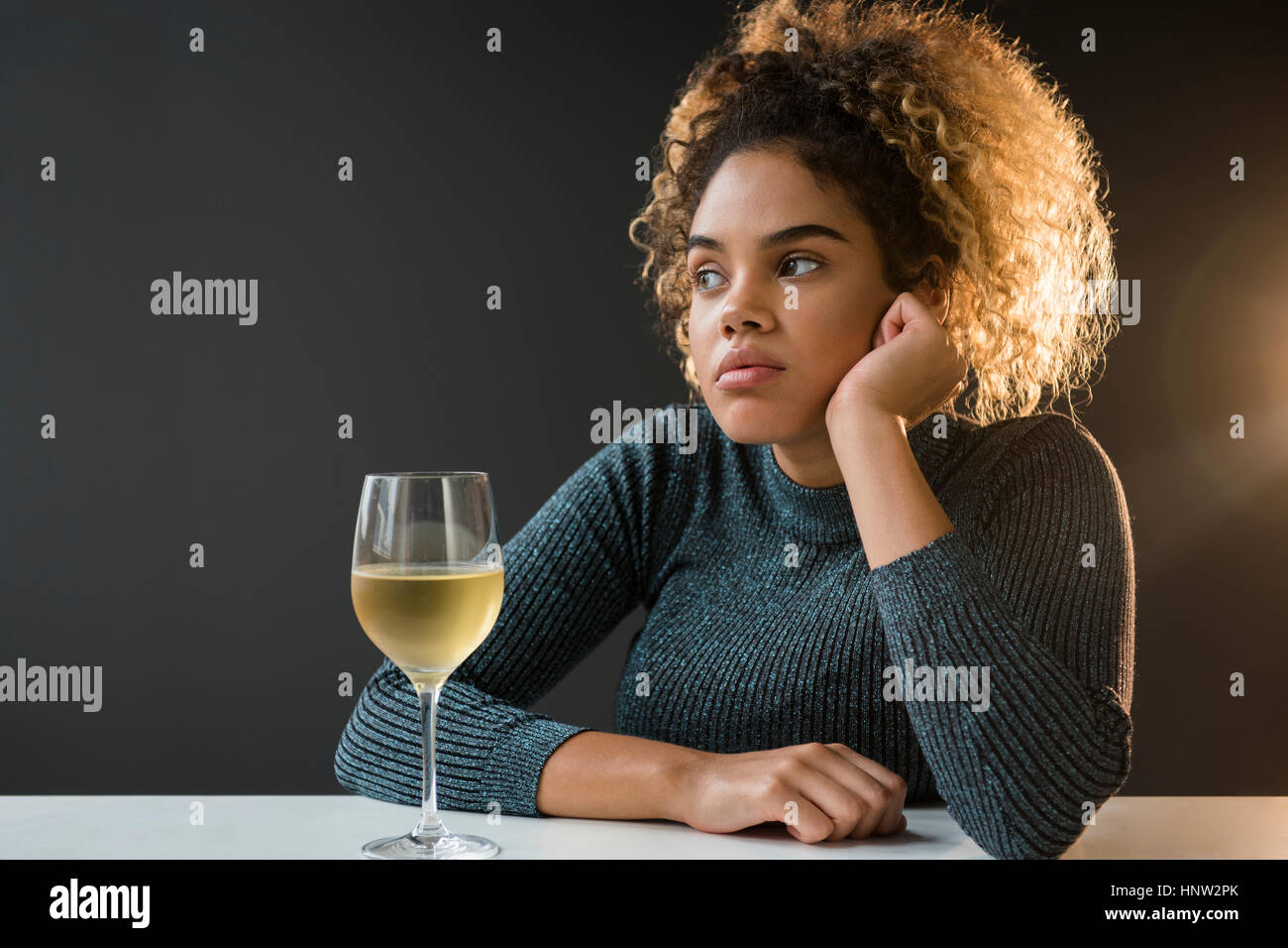 Gelangweilt Mischlinge Frau tragen Pullover Wein trinken Stockfoto