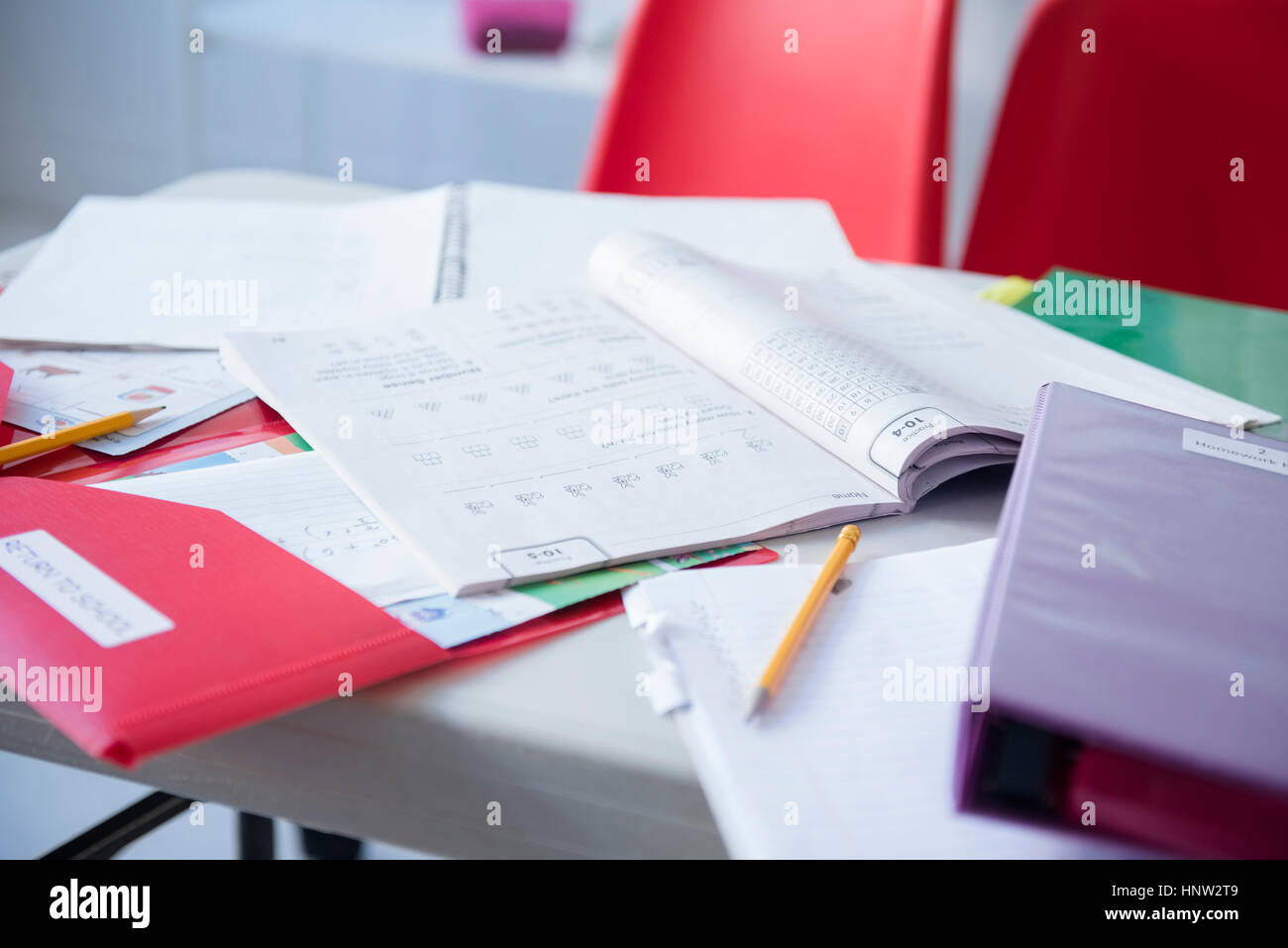 Arbeitsmappe und Ordner auf Schreibtisch im Klassenzimmer Stockfoto