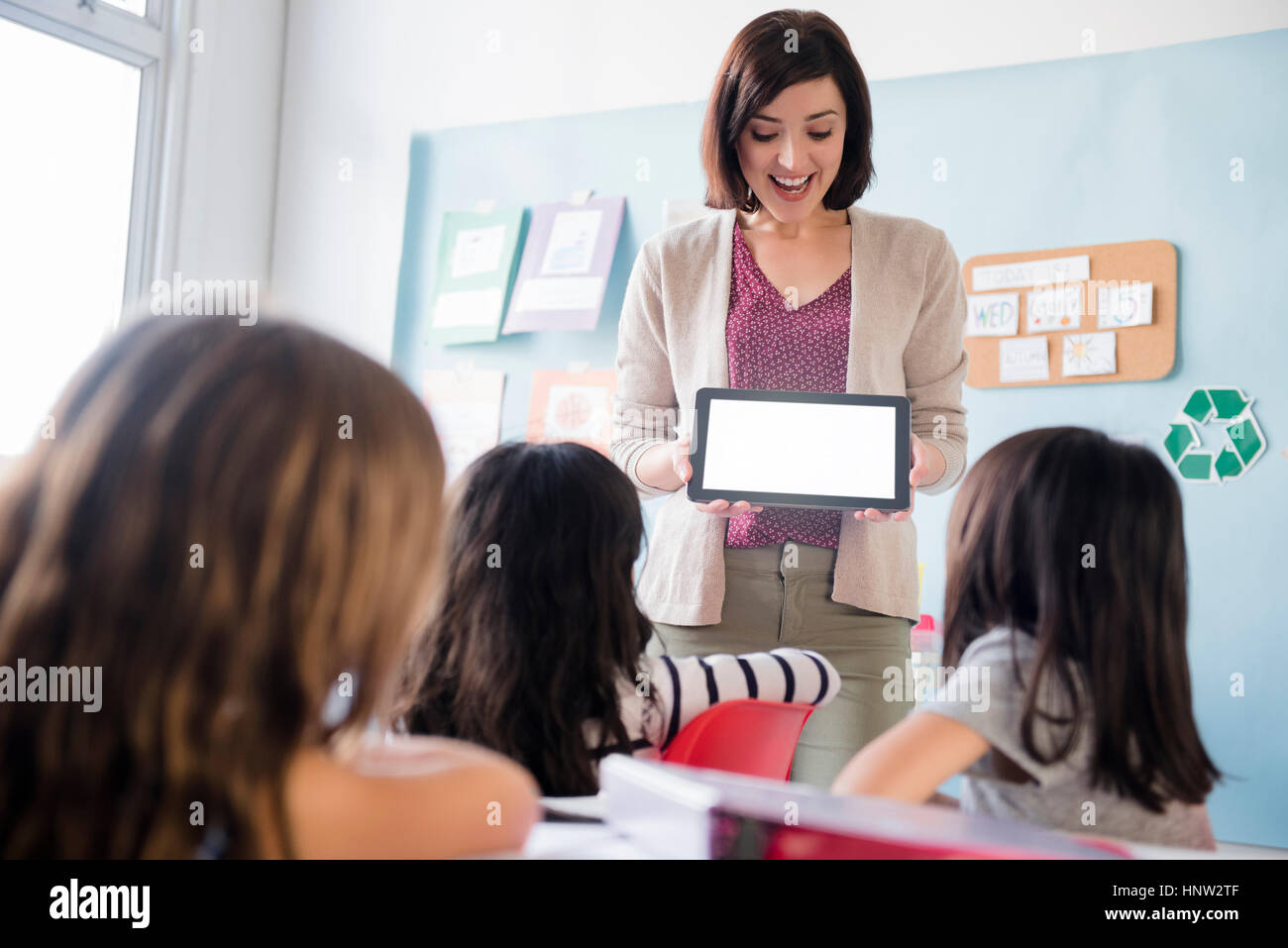 Lehrer zeigt digital-Tablette, Mädchen im Klassenzimmer Stockfoto