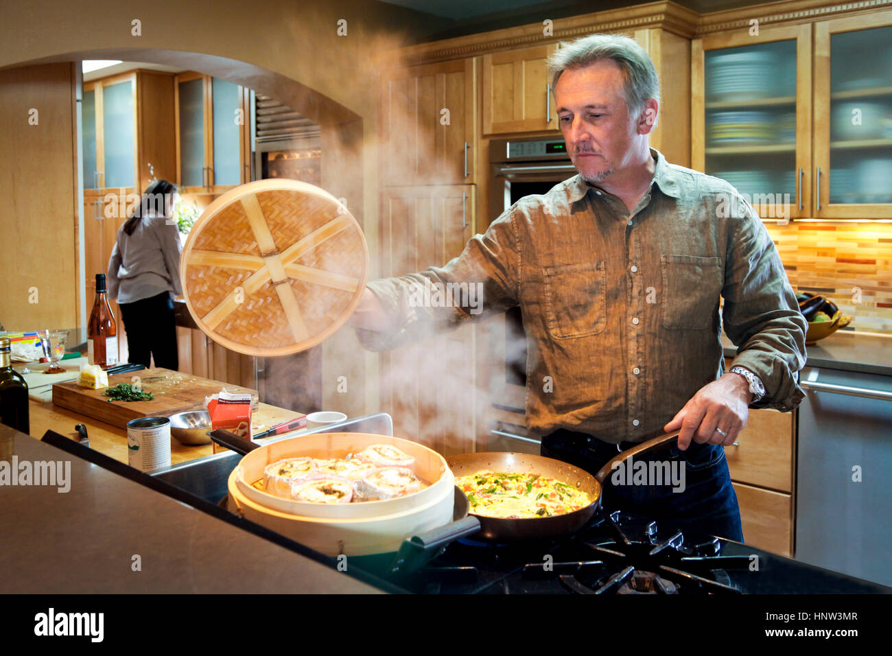 Kaukasischen Mann dampfenden Essen auf Herd Stockfoto
