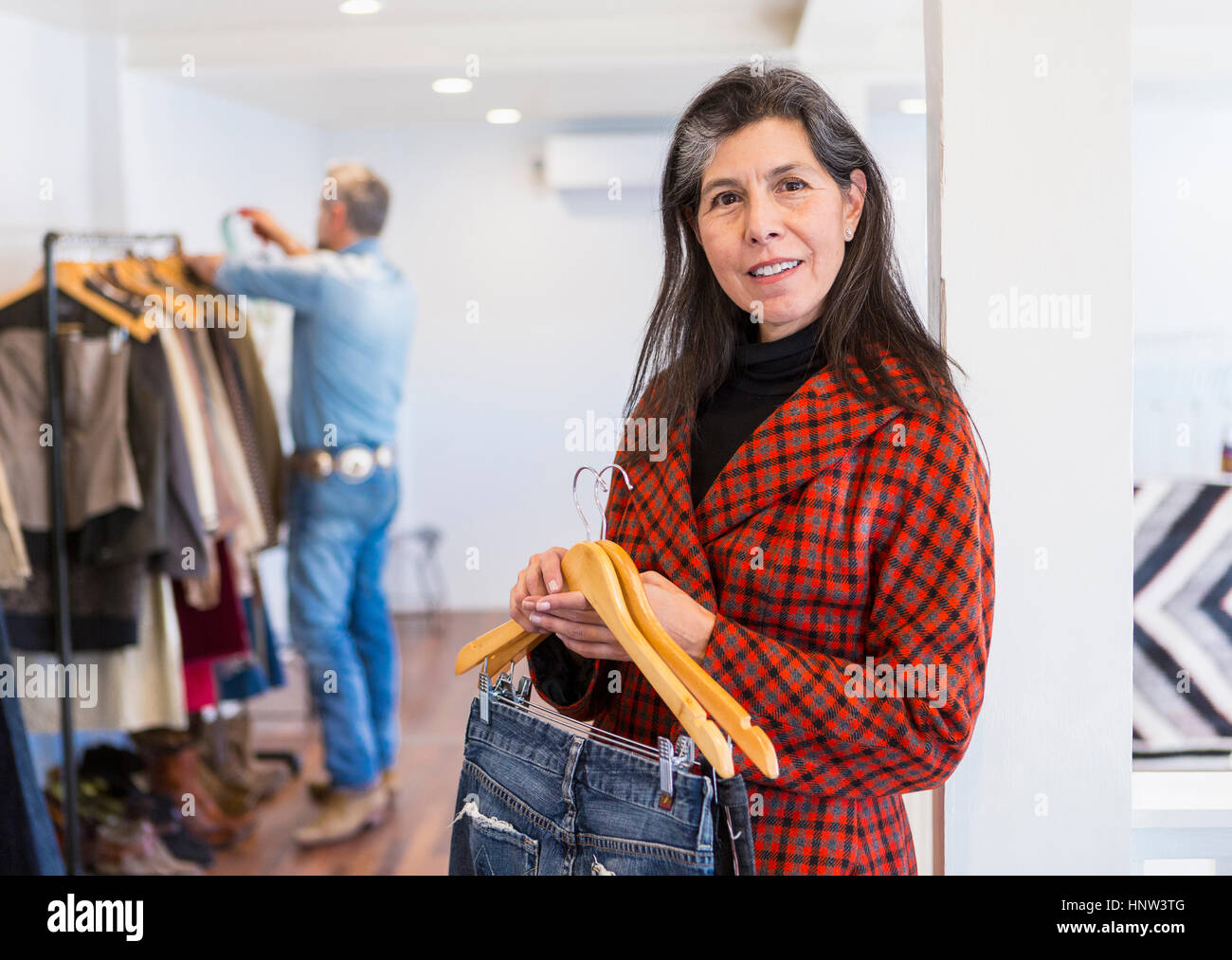 Frau shopping für Jeans in Bekleidungsgeschäft Stockfoto