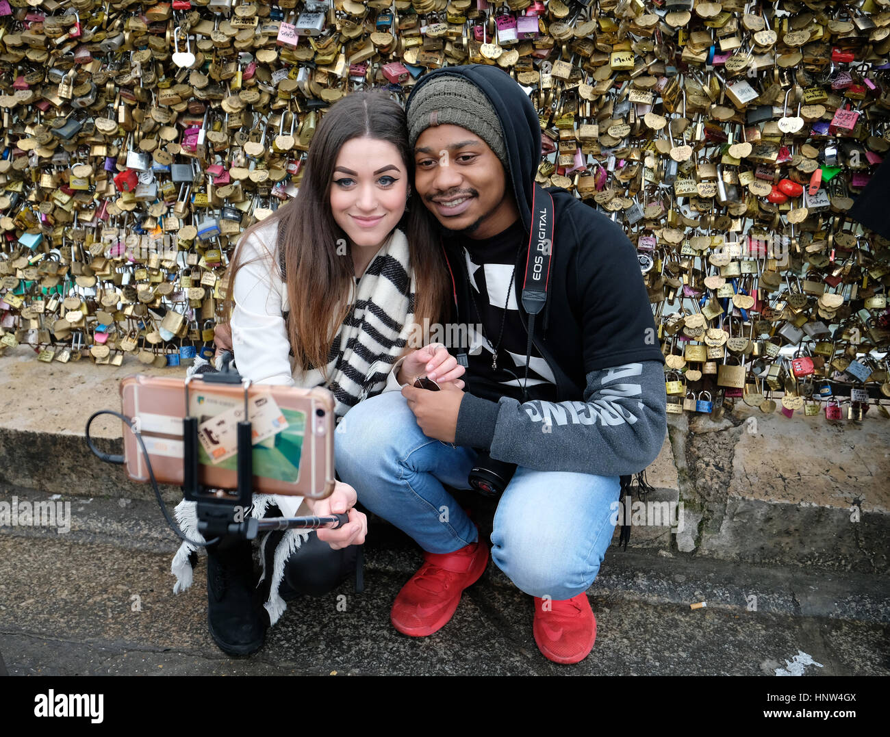 14.02.2017. Valentinstag, ein junges Paar machen Sie eine Selfie vor Liebe Schleusen an der Pont Neuf in Paris, Frankreich Stockfoto