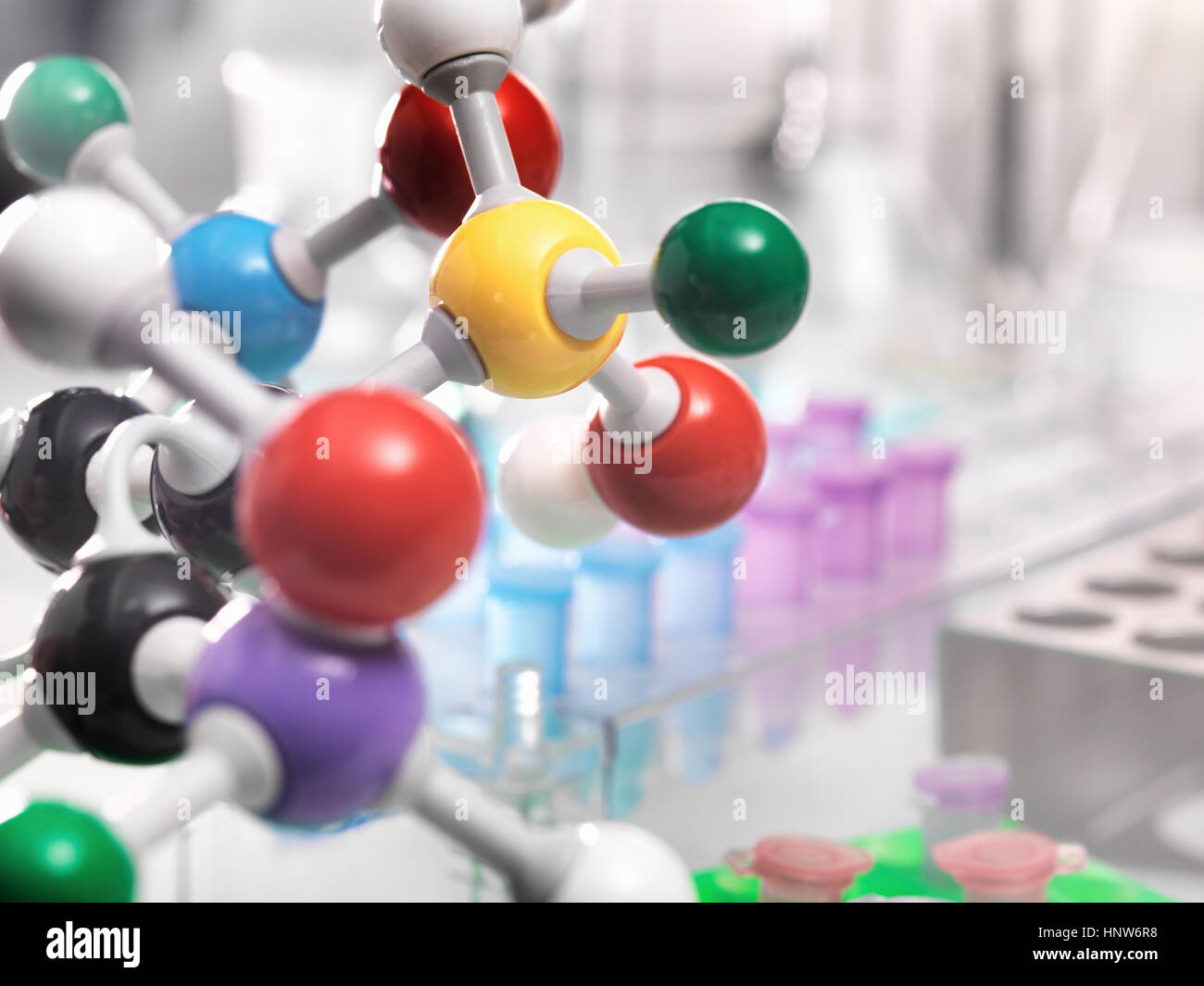 Ein molekulares Modell einer chemischen Formel mit Laborgeräten im Hintergrund Stockfoto