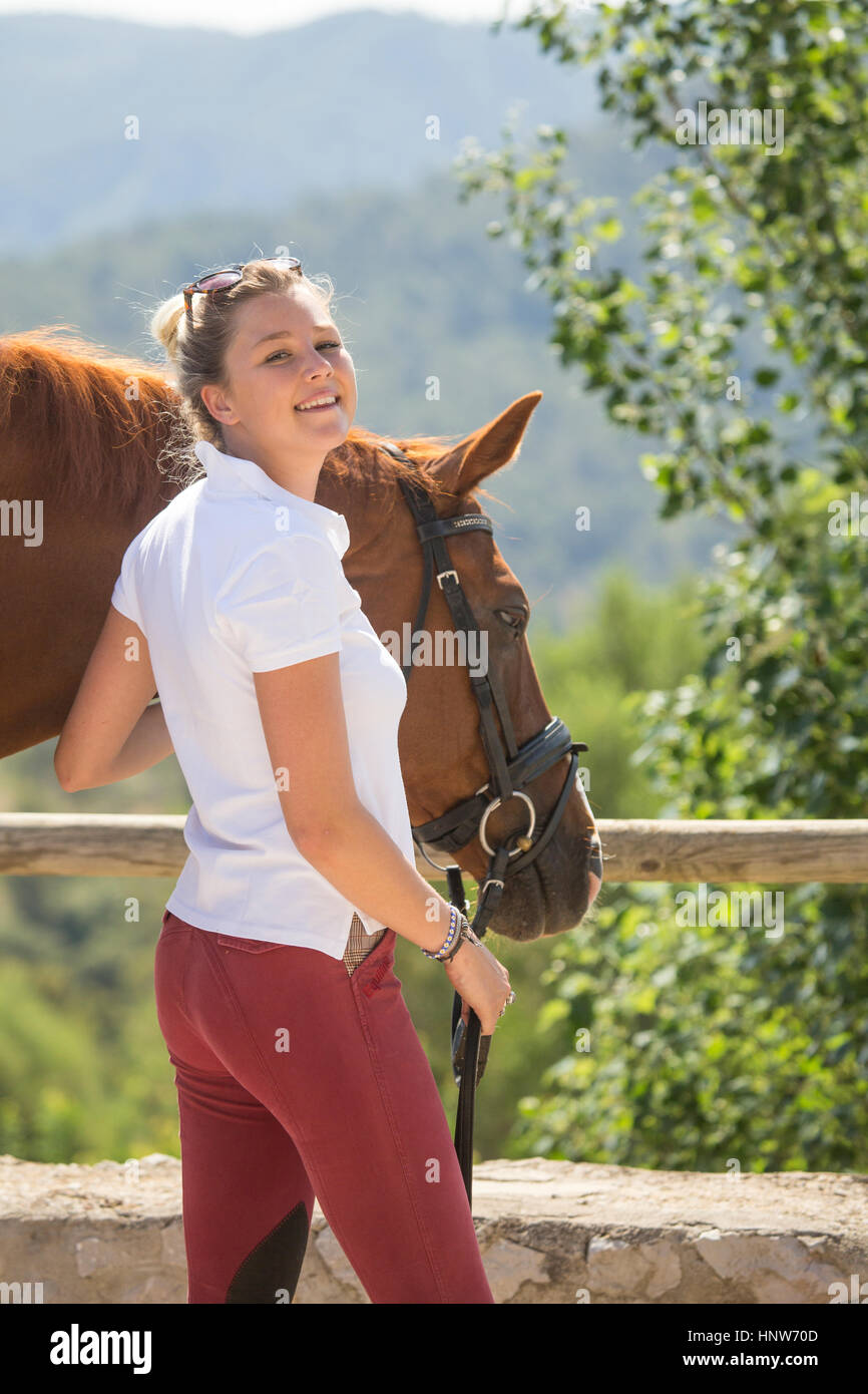 Porträt der jungen weiblichen Bräutigam mit Pferd im ländlichen stables Stockfoto