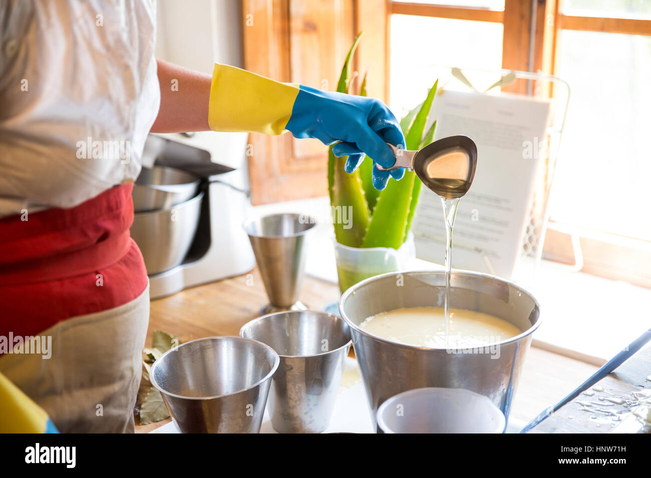 Innenfeldes Frau Lavendelöl in Schüssel in Werkstatt handgemachte Seife gießen Stockfoto