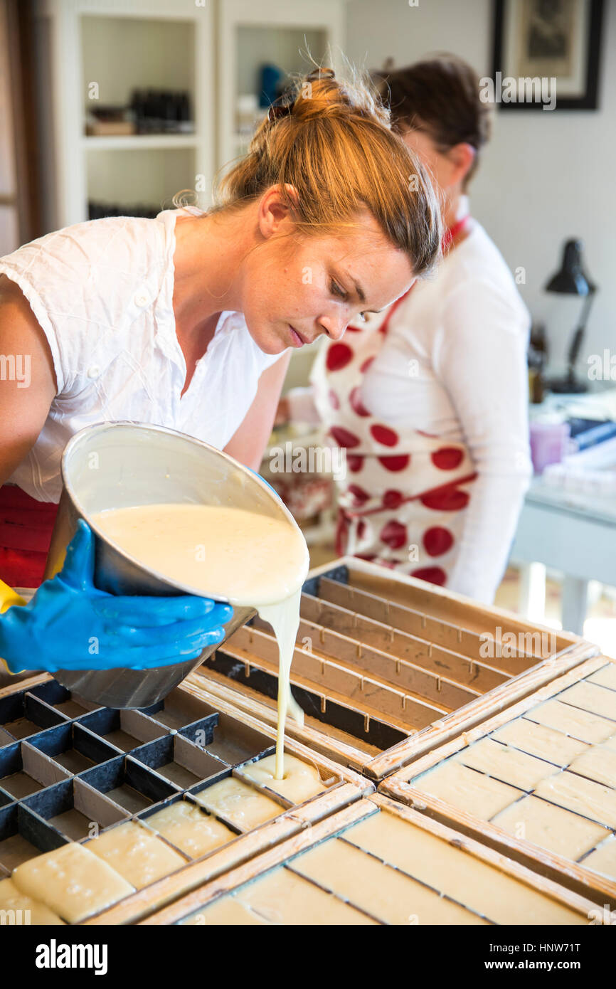 Junge Frau strömenden Flüssigkeit Lavendel Seife in Formen in handgemachte Seife Werkstatt Stockfoto