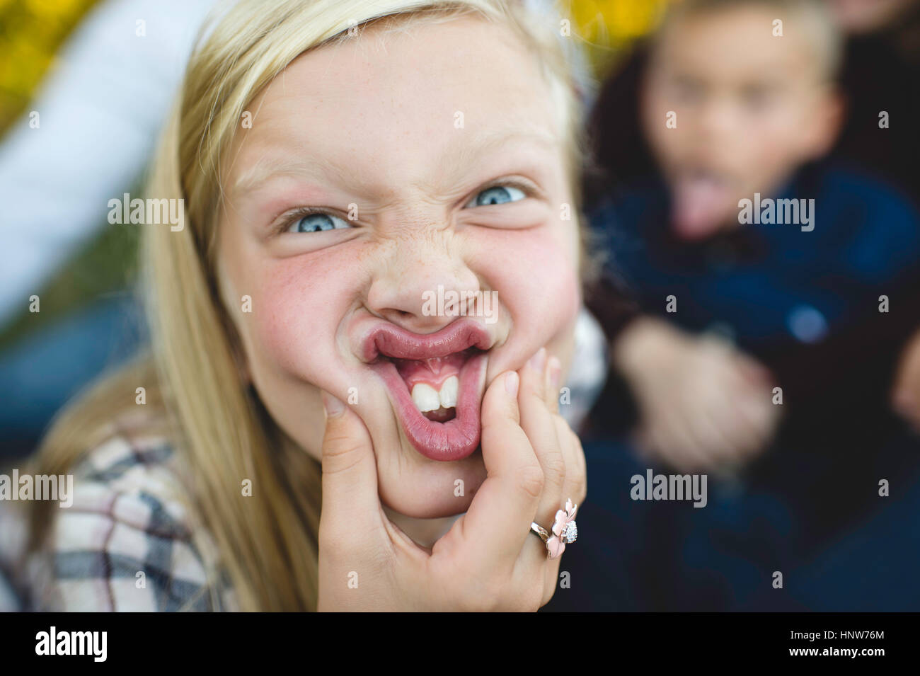 Blick in die Kamera zieht Gesicht Mädchen Stockfoto