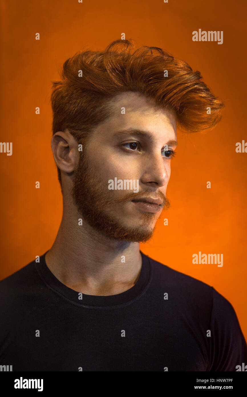 Porträt des jungen Mann mit roten Haaren vor orange Hintergrund Stockfoto