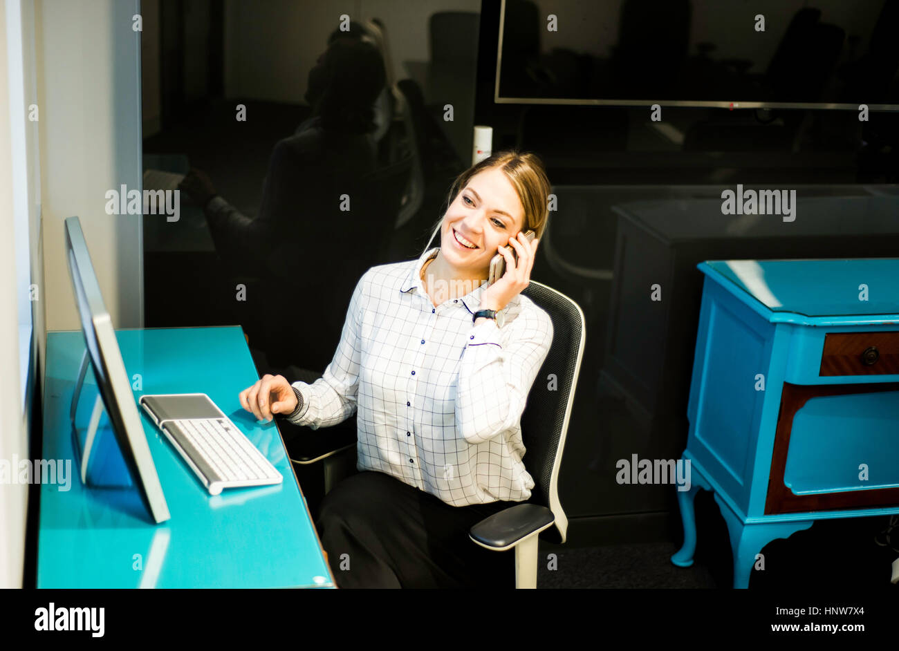 Geschäftsfrau sprechen auf Smartphone am Schreibtisch Stockfoto