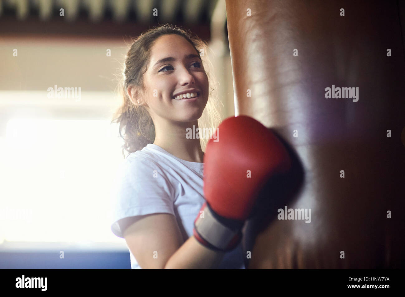 Junge Boxerin Stanzen Boxsack im Fitness-Studio Stockfoto