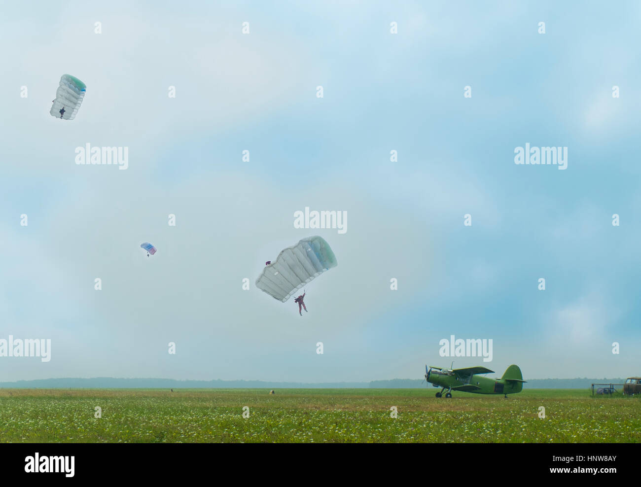 Fernsicht auf drei Personen Fallschirmspringen bis Flugplatz mit einem Oldtimer-Flugzeuge Stockfoto