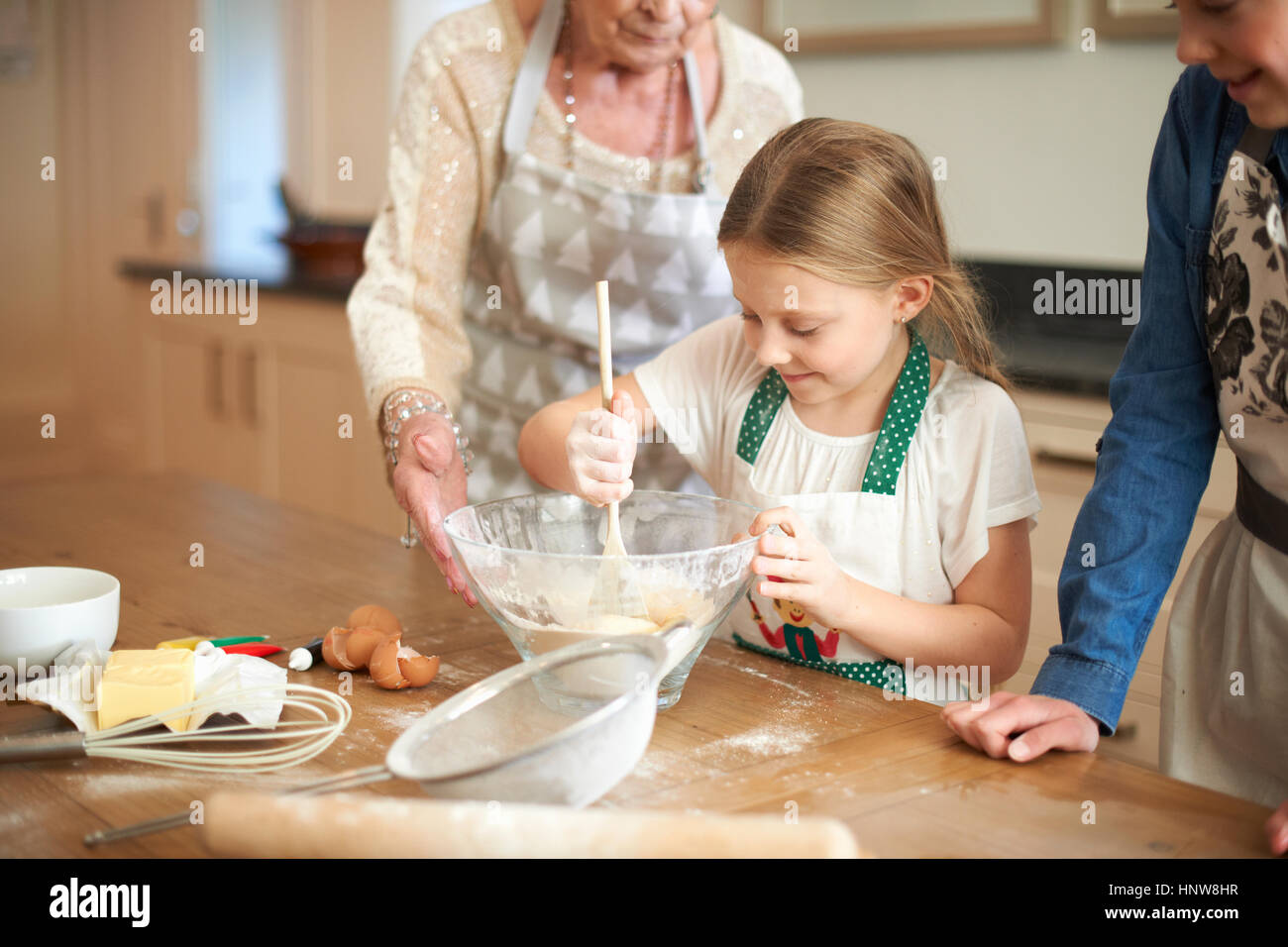 Ältere Frau und Enkelinnen Schüssel Cookie-Mischung einrühren Stockfoto