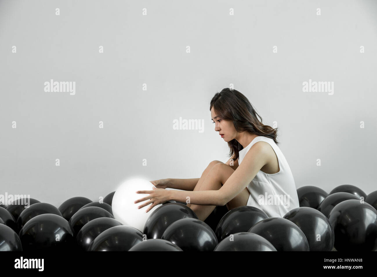 Junge Frau mit weißen Ballon unter schwarzen Stockfoto