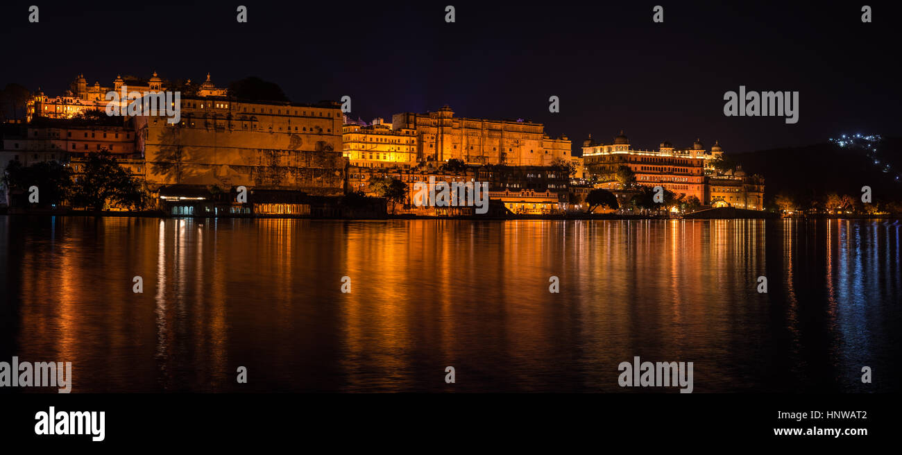 Glühende Stadtbild in Udaipur bei Nacht. Majestätische Palast reflektierenden die Lichter der Stadt am Lake Pichola, Reiseziel in Rajasthan, Indien Stockfoto